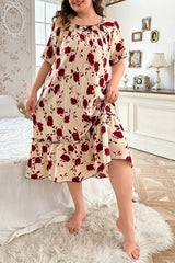 Plus size woman in a cream and red floral print short sleeve ruffled hem nightgown standing in a bedroom.