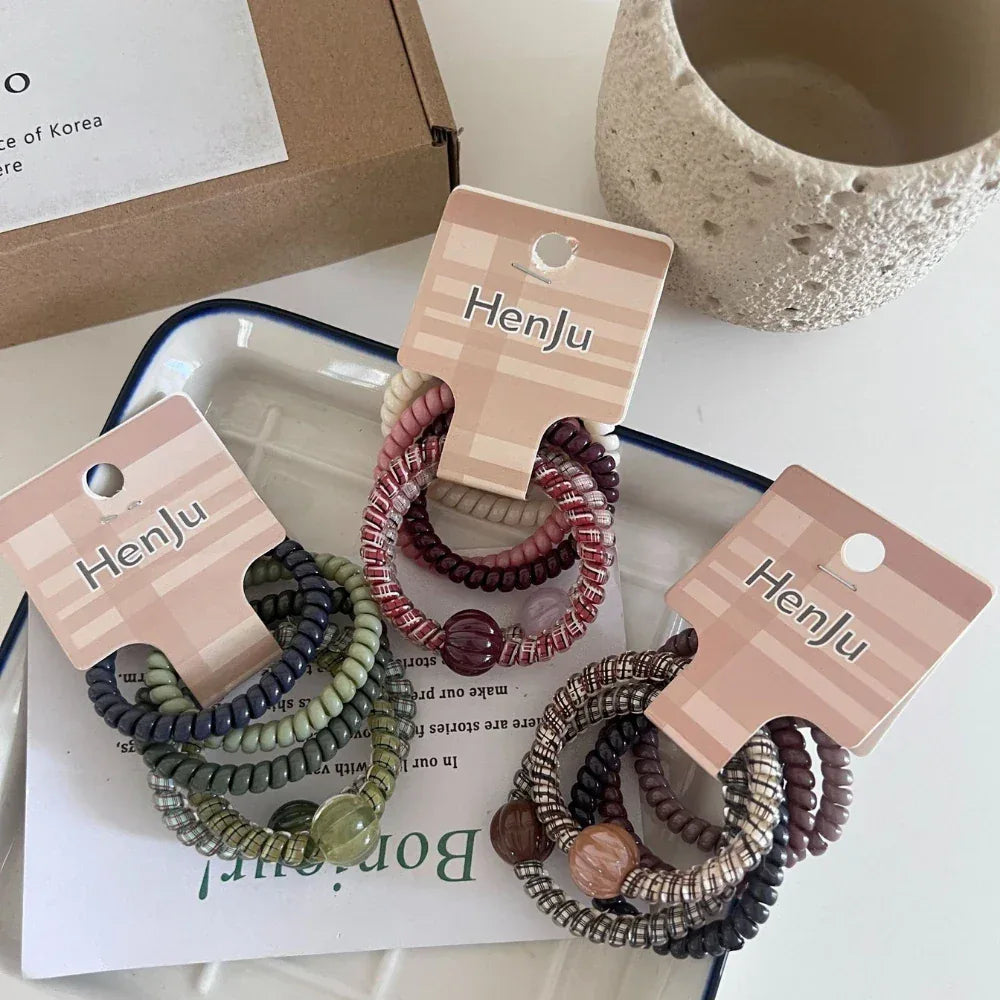 Multiple packs of spiral hair ties displayed on a tray with packaging.