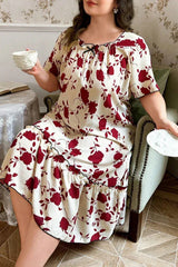 Plus size woman in a cream and red floral print short sleeve ruffled hem nightgown sitting in a chair holding a cup.