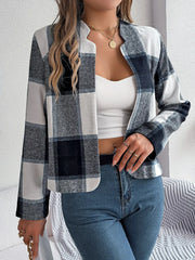 Front view of a woman wearing a cropped buffalo plaid jacket, white tank top, and blue jeans, with jewelry and a handbag.