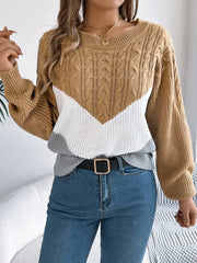 Woman wearing a brown, white, and grey colorblock chevron knit sweater with blue jeans and a black belt