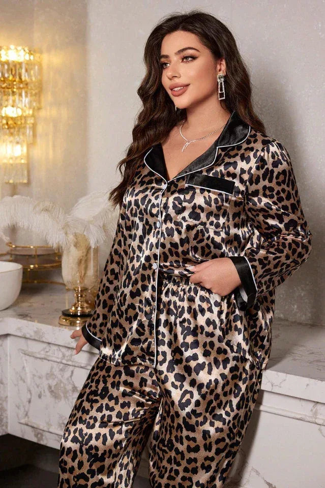 Woman wearing a leopard print satin pajama set, standing and posing.