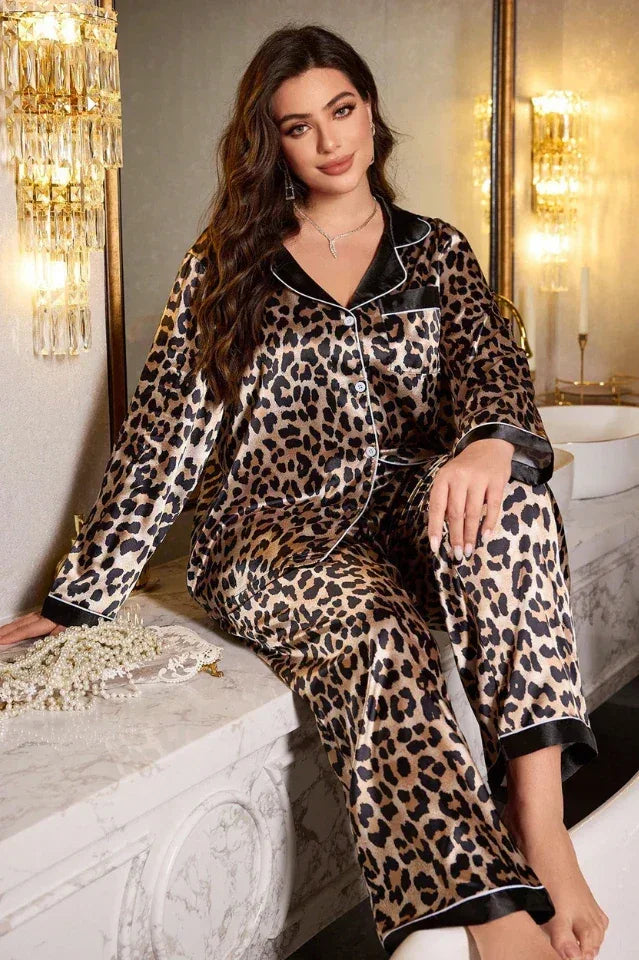 Woman wearing a leopard print satin pajama set, sitting on a marble countertop.