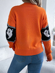 Back view of a woman wearing an orange Halloween sweater with ghost print on the sleeves.