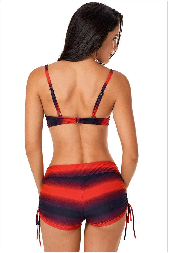 Back view of a woman wearing a red and black gradient stripe bikini