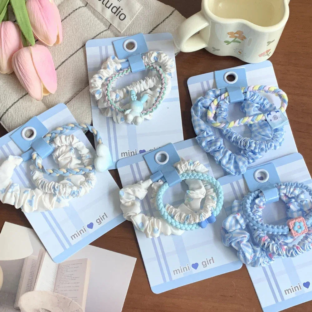 Collection of scrunchie sets with various blue and white patterns and charms
