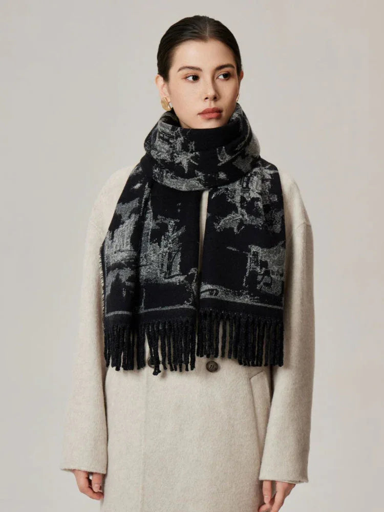 Woman wearing a black and white patterned scarf draped over a cream coat