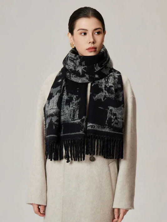 Woman wearing a black and white patterned scarf draped over a cream coat