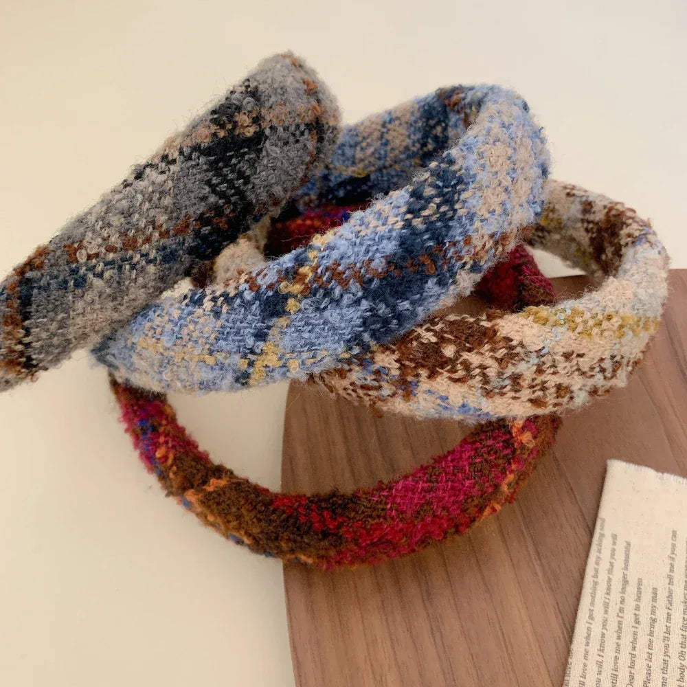 A close-up of three padded headbands with plaid patterns, highlighting their textured fabric.