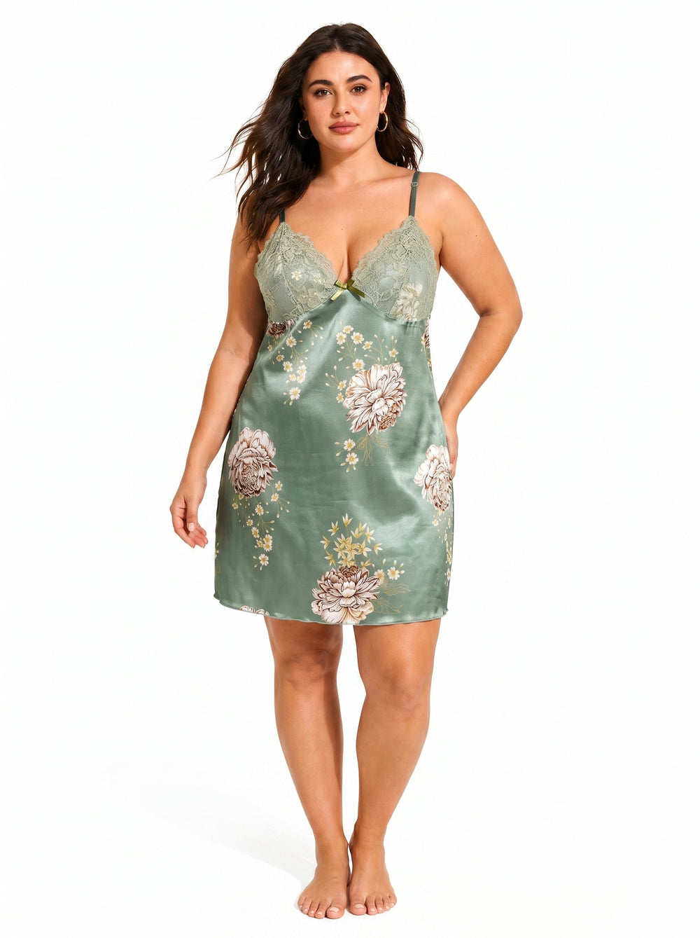 Full-body front view of a plus-size model in a green satin chemise featuring a floral print and lace neckline