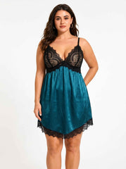 Front view of a woman wearing a teal satin slip dress with black lace detailing, with one hand behind her back.