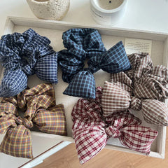 Tray filled with plaid scrunchies, each featuring a prominent bow.
