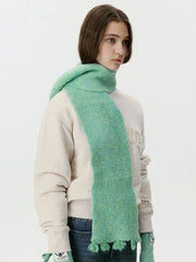 Model wearing a mint green fuzzy scarf draped around the neck