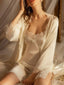 Woman wearing a cream-colored satin slip dress with lace trim and a matching lace-trimmed robe.
