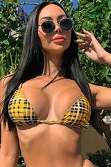 Woman wearing a yellow plaid bikini top and sunglasses