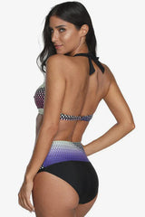 Woman wearing a multi-colored polka dot halter neck bikini with high-waisted black bottoms, back view.