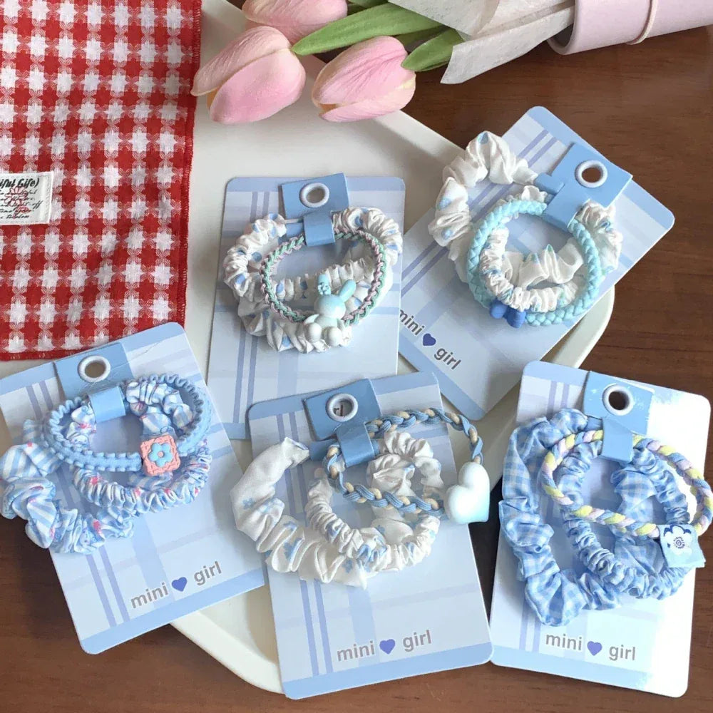Assortment of scrunchie sets displayed on a table with decorative elements