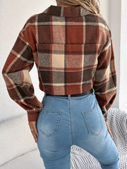 Back view of a model wearing a cropped plaid jacket and blue jeans.