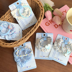 Scrunchie sets arranged in a basket and on a table with books and flowers