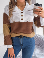 Close-up of a woman wearing a brown, tan, and white color block knit sweater with a v-neck and button details, holding a coffee cup.