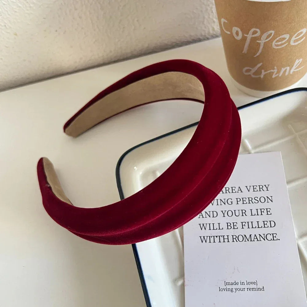 Red velvet padded headband with textured surface on a white dish