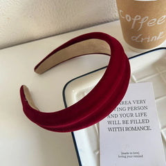 Red velvet padded headband with textured surface on a white dish