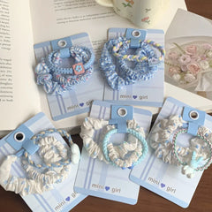 Close-up of scrunchie sets with intricate patterns and small charms