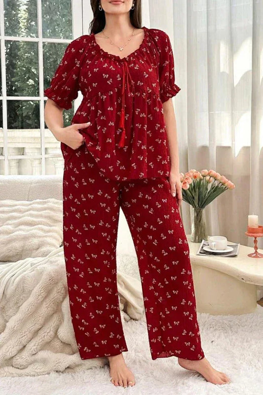 Woman wearing a red pajama set with a butterfly print, standing.