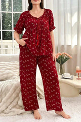 Woman wearing a red pajama set with a butterfly print, standing.