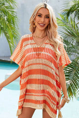 Woman wearing an orange and beige striped crocheted poncho with a V-neck and short sleeves.