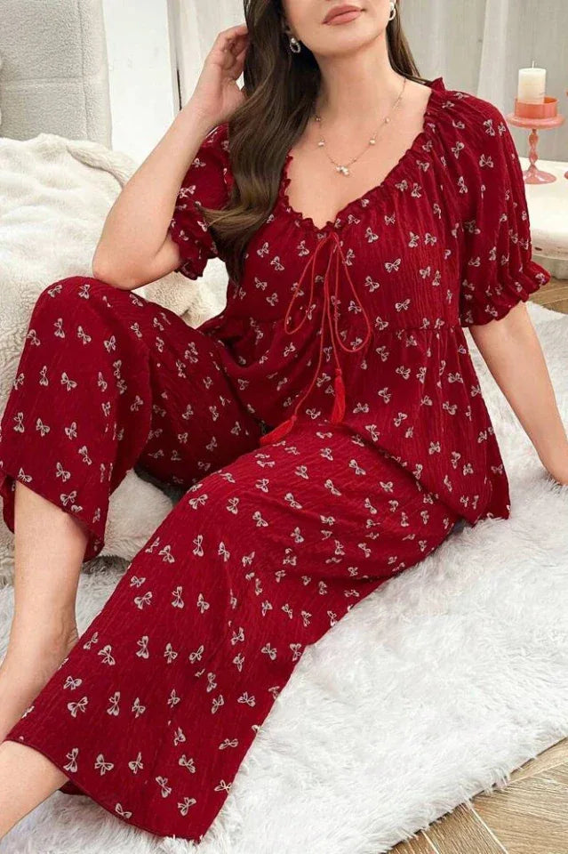 Woman wearing a red pajama set with a butterfly print, sitting on a white rug.