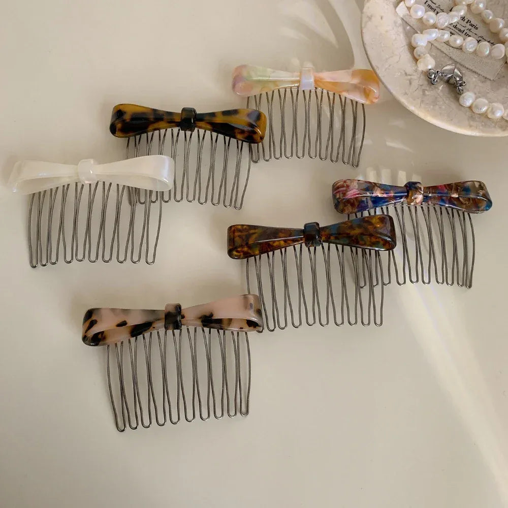 A variety of bow combs are laid out on a white surface.