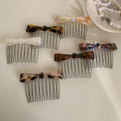 A variety of bow combs are laid out on a white surface.