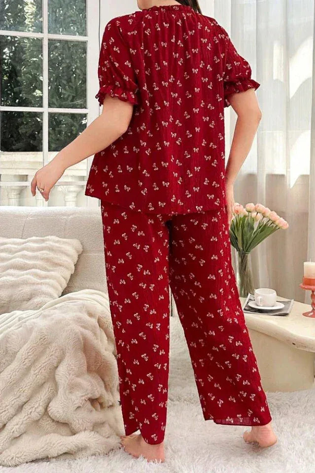 Woman wearing a red pajama set with a butterfly print, back view.