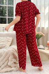 Woman wearing a red pajama set with a butterfly print, back view.