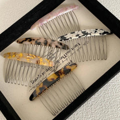 Group of decorative hair combs displayed in a tray