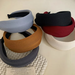 Assortment of padded headbands in different colors, including brown, grey, light blue, red, black, and cream