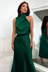 woman wearing a green satin halter neck midi dress in a dressing room