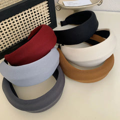 Stack of padded headbands in multiple colors: grey, light blue, red, black, cream, and brown