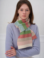 Woman wearing a blue sweater and a pastel striped scarf