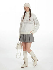 Full-body shot of a model in a winter-themed outfit, including a patterned sweater, pleated skirt, and tall socks.