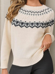 Close-up of a woman wearing a cream-colored knit sweater with a Fair Isle pattern around the yoke, showing her hand tucked into her waistband.