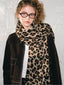 Model wearing a brown jacket with a leopard print scarf and black pants.