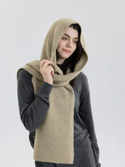 Close-up of a model wearing a gray sweater and a beige hooded scarf around her neck.