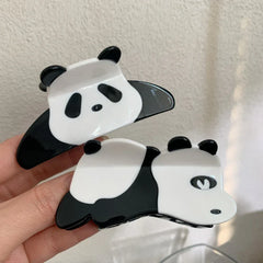 Two panda hair claw clips held in a hand