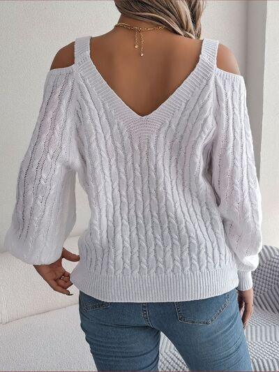 back view of a woman wearing a white cold shoulder cable knit sweater