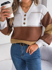 Close-up of a woman wearing a brown, tan, and white color block knit sweater with a v-neck and button details, holding a coffee cup and showing off her belt.
