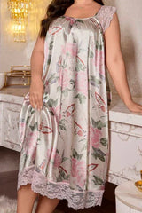 Woman leaning on a counter while wearing a floral and butterfly print satin nightgown with lace trim.