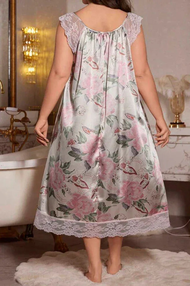 Back view of a woman in a floral and butterfly print satin nightgown with lace trim.