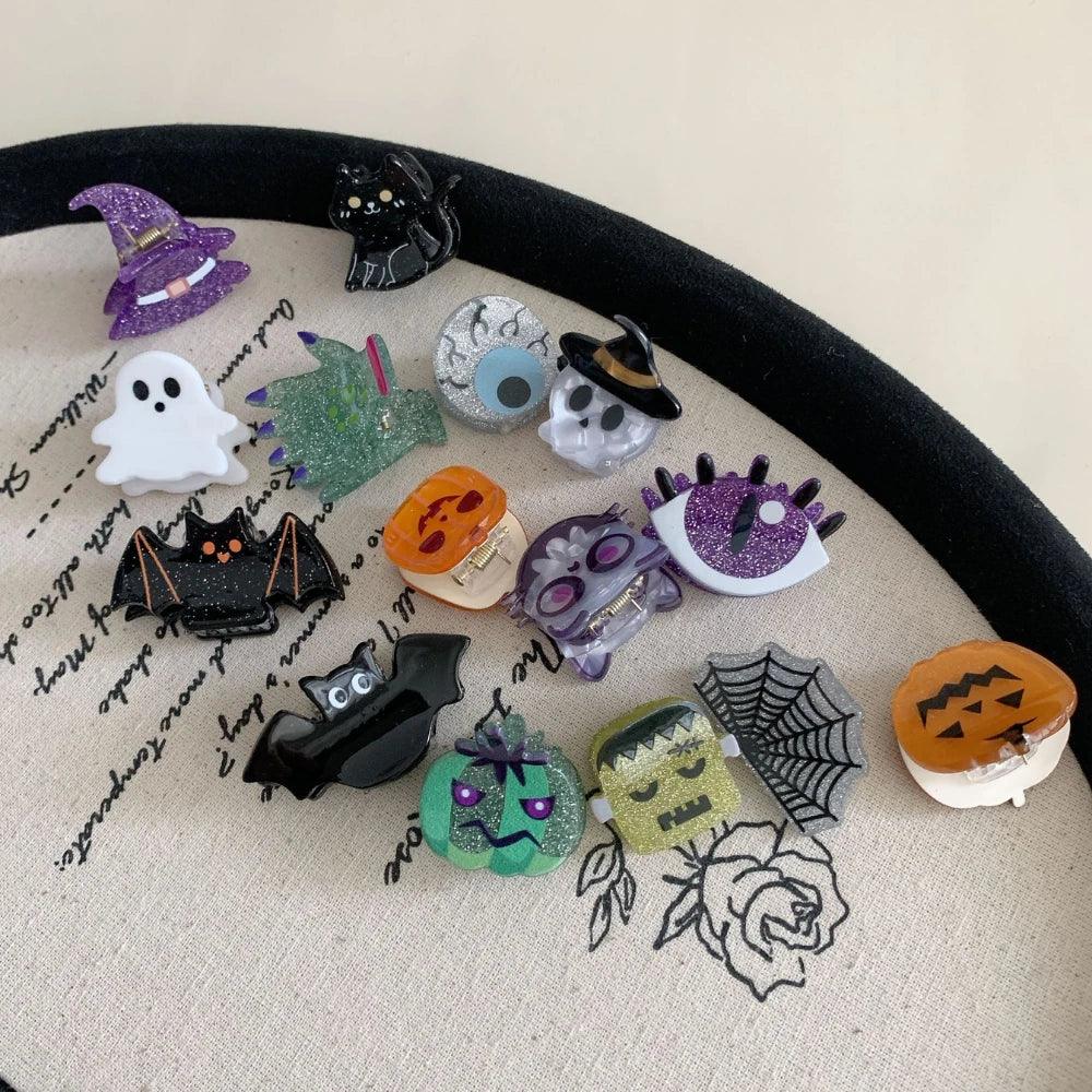 Collection of Halloween-themed hair clips including a witch hat, ghost, bat, pumpkin, skull, cat, spiderweb, and monster